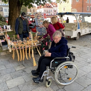 Uczestnicy Dziennego Domu Senior+ w trakcie zakupu pamiątek na sandomierskim kramie. 